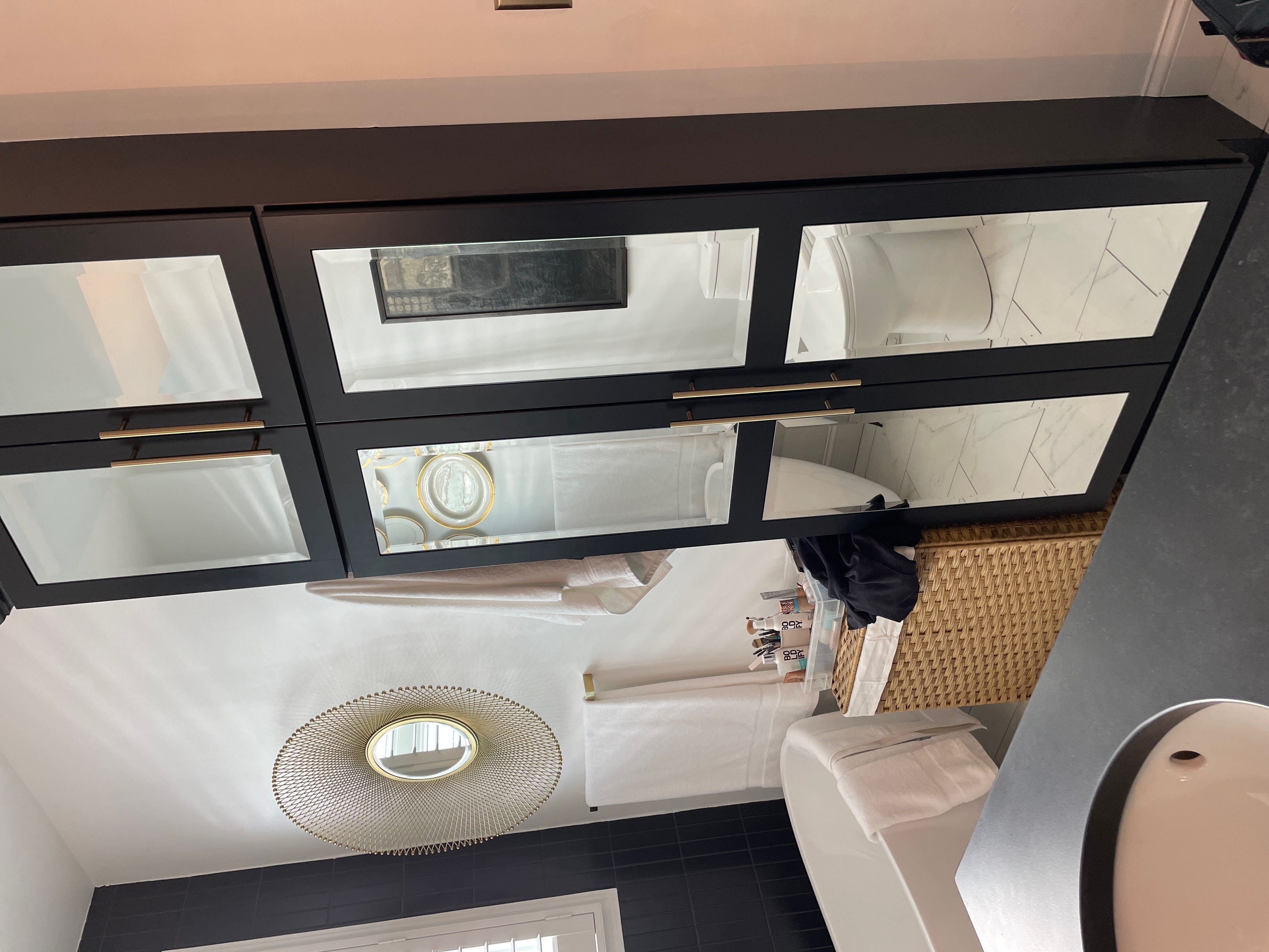 Custom black-framed mirror cabinet installation